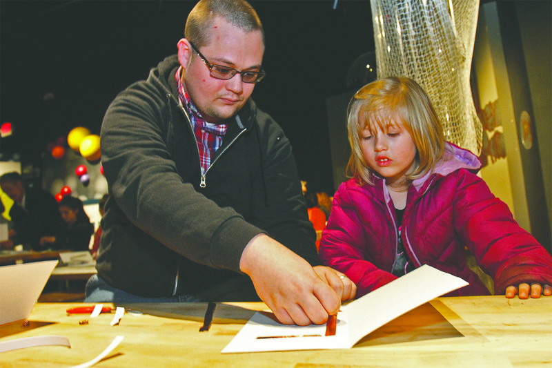 Illuminating cards: Aaron Richardson and his daughter, Lauren of Harmony Grove attend the Tinker Time workshop in Smackover on Saturday. Richardson, his daughter and other attendees constructed circuits with switches while builing illuminating greeting cards for Valentine's Day. Terrance Armstard/News-Times