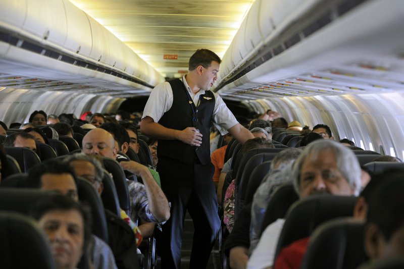 FILE- In this May 9, 2013, file photo, Allegiant Air flight attendant Chris Killian prepares his passengers for the Laredo, Tex, bound flight before it pushes back from the terminal at McCarran International Airport in Las Vegas. Smaller-company stocks like Allegiant Travel and Shutterfly have been soaring since late December and leading the rest of the market, a sharp reversal from much of the winter, when smaller stocks were plunging more than the rest of the market. (AP Photo/David Becker, File)