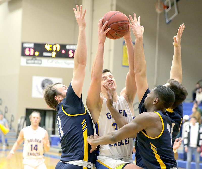 Photo courtesy of John Brown University John Brown senior Josh Bowling fights through a crowd of Wayland Baptist players for a shot during Thursday's game at Bill George Arena. Bowling scored 20 points and JBU defeated the Pioneers 75-72.