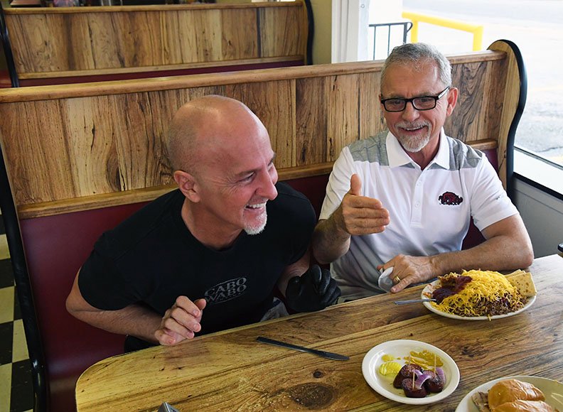 The Sentinel-Record/Grace Brown OLD FRIENDS: Roger Scott, right, a popular morning DJ with 103.7 The Buzz, shares a laugh with his old friend, Scott McClard, at McClard's restaurant Tuesday as Scott discusses his role in the recently released feature film, "Antiquities." The Arkansas set film has made the rounds of film festivals across the country and is now available to buy or rent.