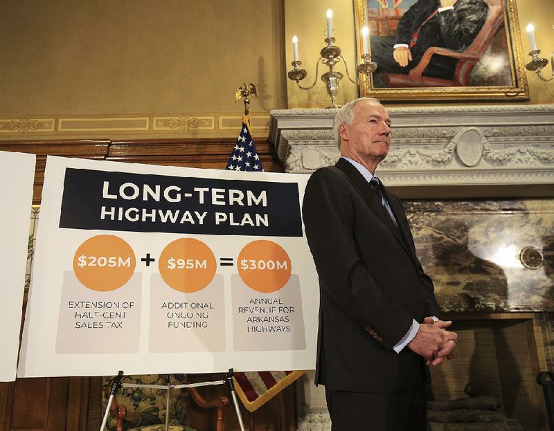 FILE - Gov. Asa Hutchinson listens Feb. 11, 2019 during a news conference at the state Capitol where he unveiled his highway plan. Legislative leaders were commenting about the proposal that would permanently extend a half-percent sales tax, increase fuel taxes and tap casino revenue. 