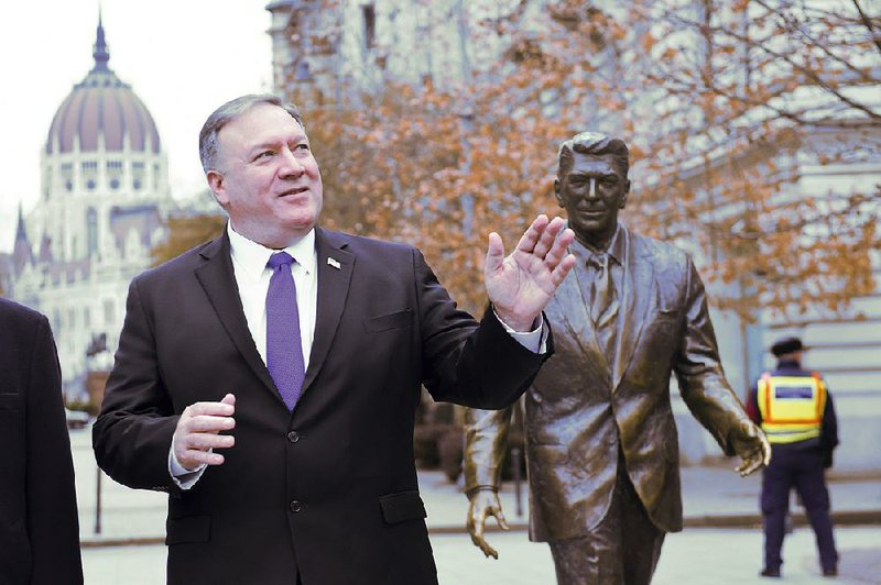 U.S. Secretary of State Mike Pompeo stands Monday next to a sculpture of former U.S. President Ronald Reagan at Liberty Square in Budapest, Hungary. 