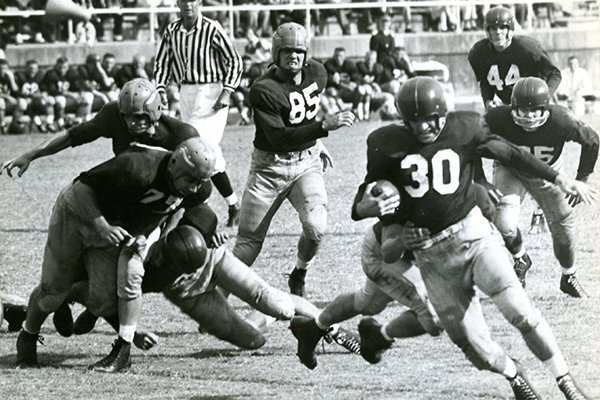 Arkansas back Henry Moore (30) runs during a game against Ole Miss on Saturday, Oct. 23, 1954, in Little Rock. George Walker (44) is shown watching the play from behind. 