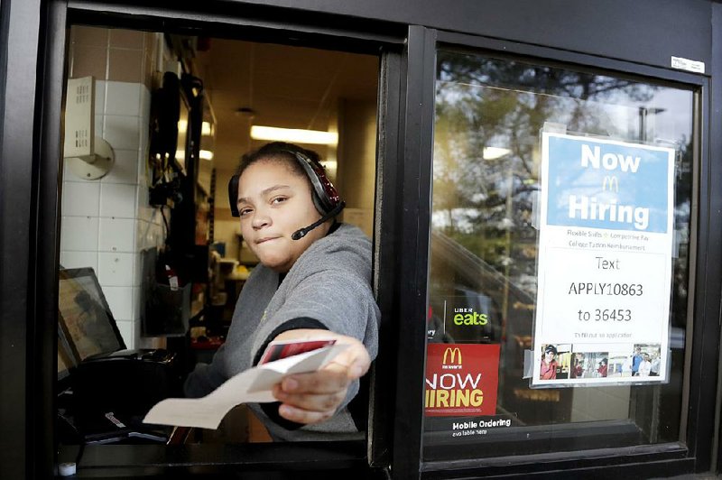A cashier returns a credit card and a receipt last month at a McDonald’s in Atlantic Highlands, N.J., where signs for job openings are displayed in the window.