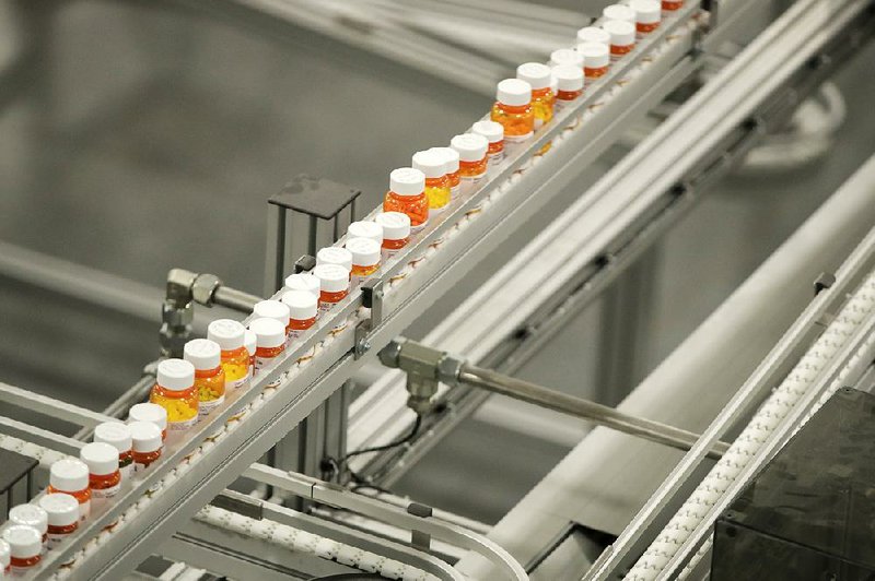 Bottles of medicine ride on a conveyor belt last year at the Express Scripts mail-in pharmacy warehouse in Florence, N.J. Democrats in Congress who are considering a revamped North American trade pact contend that it would raise prescription drug prices in the U.S. 