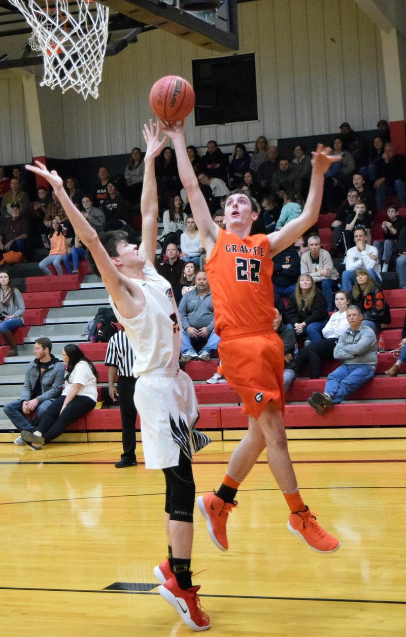 Westside Eagle Observer/MIKE ECKELS Wes Wales (Blackhawks 23) and Johnny Dunfee (Lions 22) fight for control of a rebound during the Pea Ridge-Gravette conference contest in Pea Ridge Feb. 8. In the final regular season game for both teams, the Blackhawks emerged triumphant, taking the win, 47-45, over the Lions.