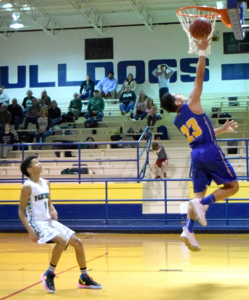 Westside Eagle Observer/MIKE ECKELS Andres Revolorio (Decatur 23) shoots a layup during the fourth quarter of the Decaur-Yellville junior high district tournament contest in Decatur Feb. 7. Revolorio lead the Bulldogs scoring drive with 11 points for the night.