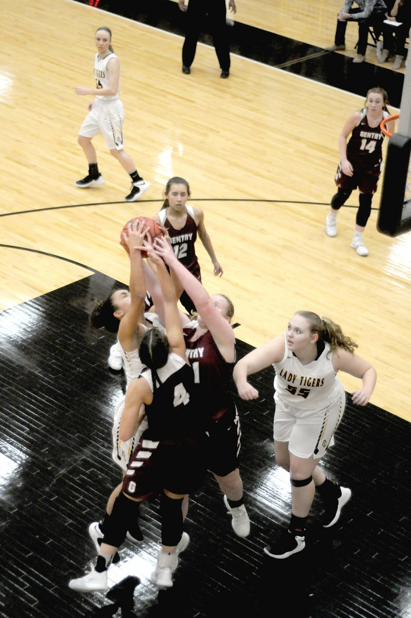 Mark Humphrey Special to the Eagle-Observer/Gentry sophomores Randi Jo Bolinger (No. 4) and Emily Toland battle Prairie Grove's Jasmine Wynos for control of the basketball. Prairie Grove defeated the Lady Pioneers, 50-30, Friday.