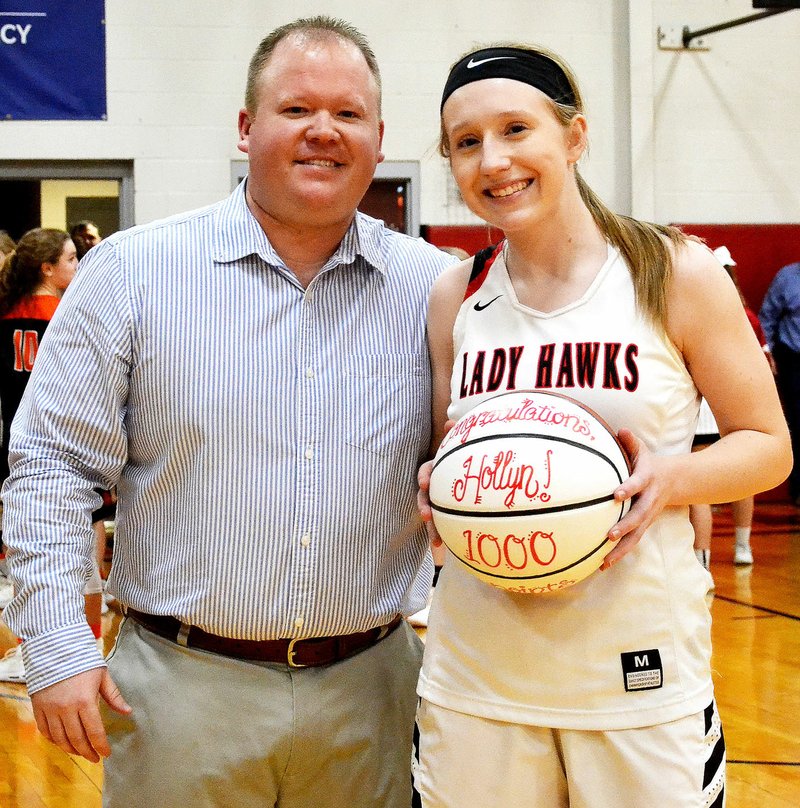 TIMES photograph by Annette Beard Senior Hollyn Davis hit the 1,000-point mark Friday night in the hard-fought battle against the Lady Lions from Gravette. Head coach Heath Neal presented Davis with a signed basketball as she was honored after the game marking the feat.