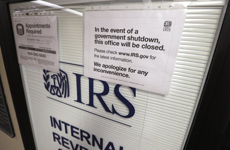 In this Jan. 16, 2019, file photo doors at the Internal Revenue Service (IRS) in the Henry M. Jackson Federal Building are locked and covered with blinds as a sign posted advises that the office will be closed during the partial government shutdown in Seattle. Disruptions from last month's partial government shutdown caused a "shocking" deterioration in the IRS' telephone help for taxpayers in the first week of the filing season, the agency's watchdog said in a report released Tuesday, Feb. 12. (AP Photo/Elaine Thompson, File)