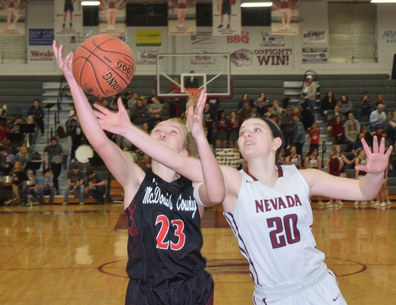 RICK PECK/SPECIAL TO MCDONALD COUNTY PRESS McDonald County's Kristin Penn battles with Nevada's Teagan Charles for a rebound during the Lady Mustangs' 58-22 loss to the Lady Tigers on Feb. 8 at Nevada High School.