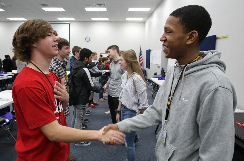 NWA Democrat-Gazette/DAVID GOTTSCHALK Hayden Duffel (left) practices a hand shake and greeting Wednesday with Khaliq Pulluaim, both freshmen at Central Junior High School during the Game Changer Diversity Seminar with Sidney Moncrief at the Springdale school. Students from seven schools in Northwest Arkansas participated in the We Are One Diversity &amp; Inclusion Initiative.