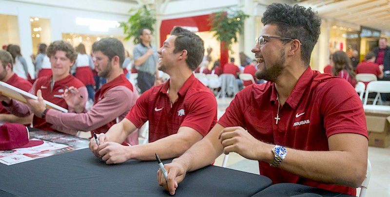 NWA Democrat-Gazette/Ben Goff IT'S A START: Arkansas' starting pitcher Isaiah Campbell, right, and center fielder shared a laugh Saturday during the baseball team's annual Meet the Razorbacks Day at Northwest Arkansas Mall in Fayetteville. Their first game of the season is scheduled for today against Eastern Illinois at 3 p.m.