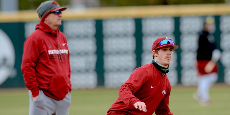 NWA Democrat-Gazette/Andy Shupe ALL-SEC: (Left) Arkansas shortstop Casey Martin takes part in a base-stealing drill on Jan. 25 in front of head coach Dave Van Horn at Baum-Walker Stadium in Fayetteville. (Right) Right fielder Heston Kjerstad warms up during the team practice.