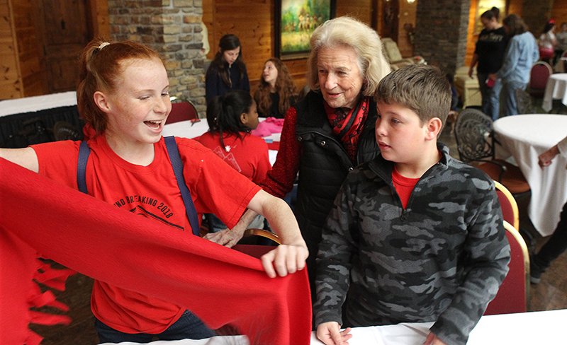 The Sentinel-Record/Richard Rasmussen INTERGENERATIONAL: The Atrium at Serenity Pointe resident Polly Barnett, center, helps Cutter Morning Star students Addison Langfor, left, and Mark Lusher make a scarf during a Share the Love Day event.