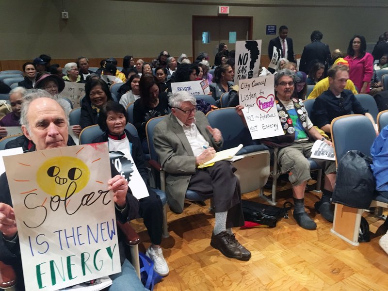 Opponents of a planned gas-fired power plant for eastern New Orleans are part of the crowd gathered for a city council committee hearing on Thursday, Feb. 14, 2019 in New Orleans. The hearing included discussions of a $5 million proposed penalty for Entergy New Orleans over the use of phony paid supporters who showed up at previous hearings in the project. (AP Photo/Kevin McGill)