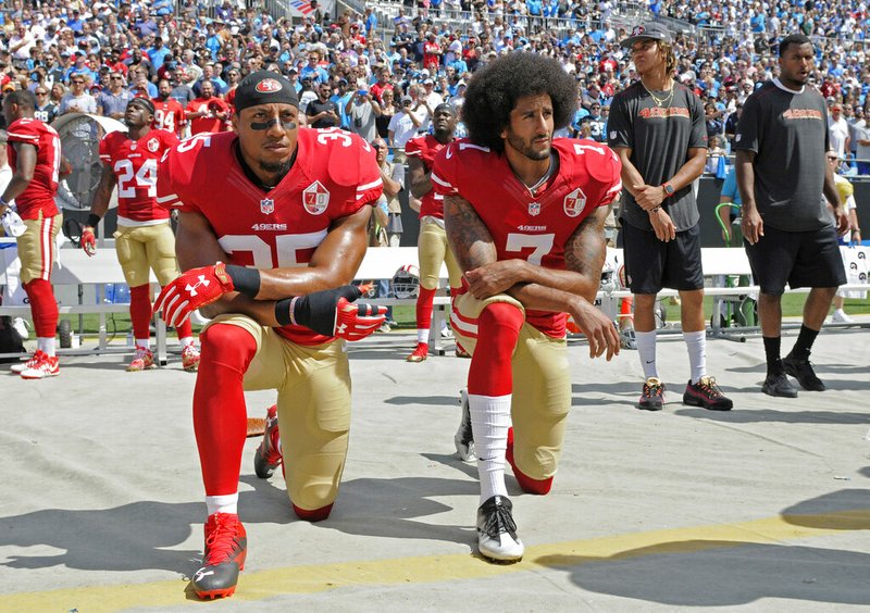 In this Sept. 18, 2016, file photo, San Francisco 49ers' Colin Kaepernick (7) and Eric Reid (35) kneel during the national anthem before an NFL football game against the Carolina Panthers, in Charlotte, N.C. Colin Kaepernick and Eric Reid have reached settlements on their collusion lawsuits against the NFL, the league said Friday, Feb. 19, 2019. (AP Photo/Mike McCarn, File)