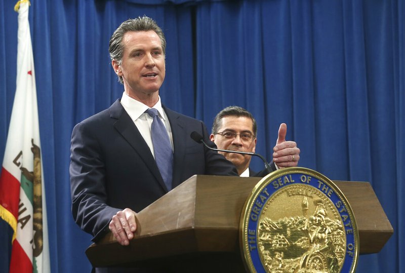 California Gov. Gavin Newsom, left, flanked by Attorney General Xavier Becerra, right, answers a question concerning a lawsuit the state will likely file against President Donald Trump over his emergency declaration to fund a wall on the U.S.-Mexico border Friday, Feb. 15, 2019, in Sacramento, Calif. Newsom and Becerra both say there is no emergency at the border and Trump doesn't have the authority to make the declaration. (AP Photo/Rich Pedroncelli)