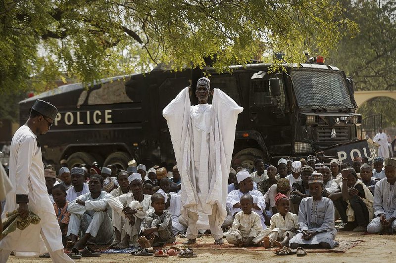 Muslims pray Friday in Kano, Nigeria, in front of a police vehicle as authorities provided security against possible attacks by Boko Haram militants. 