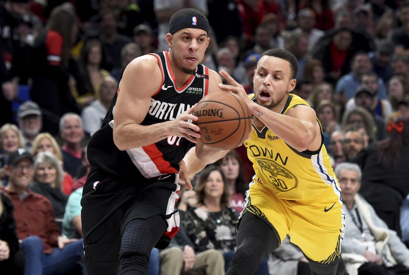 Portland Trail Blazers guard Seth Curry, left, drives to the basket on Golden State Warriors guard Stephen Curry during the second half of an NBA basketball game in Portland, Ore., Wednesday, Feb. 13, 2019. The Blazers won 129-107. (AP Photo/Steve Dykes)