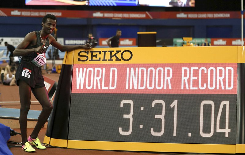 Ethiopia's Samuel Tefera poses next to teh time indicator, as he celebrates getting the mens 1500 metre World Indoor Record during the Muller Indoor Grand Prix in Birmingham, England, Saturday Feb. 16, 2019. (David Davies/PA via AP)