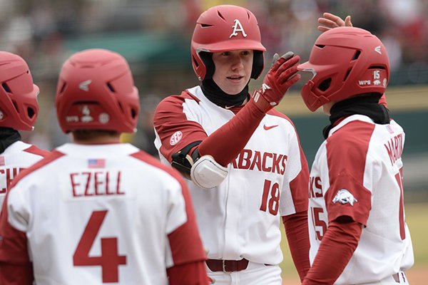 Arkansas right fielder Heston Kjerstad (center) is congratulated at the plate by shortstop Casey Martin (right) against Eastern Illinois Saturday, Feb. 16, 2019, during the inning at Baum-Walker Stadium in Fayetteville. 