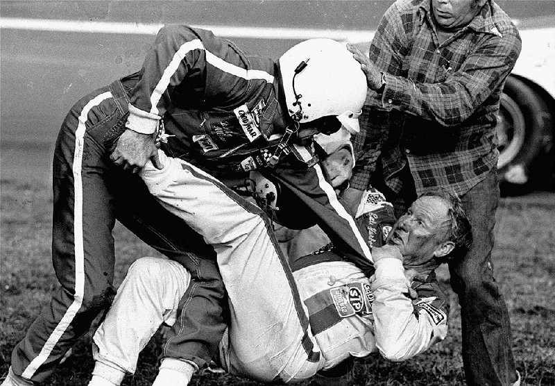 NASCAR drivers Bobby Allison (left) and Cale Yarborough fight in the infield grass and mud after Yarborough and Donnie Allison, Bobby’s brother, crashed while racing for the victory on the final lap of the 1979 Daytona 500. Richard Petty was the winner. Forty years later, the race still resonates as one of the most important in NASCAR history. 