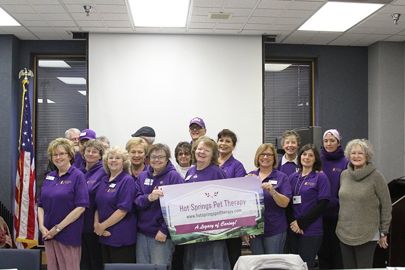 Members of the Hot Springs Pet Therapy, Inc. pose with their banner after a recent meeting