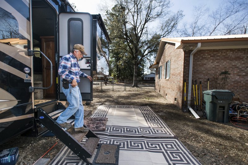 Kevin Tovornik exits his travel camper located in the back yard of his home damaged by flooding from Hurricane Florence near the Crabtree Swamp Friday, Feb. 1, 2019, in Conway, S.C. Tovornik lost his air conditioner and duct work in the 2016 flood. In 2018, he saved his furniture, but still ended up losing the house.