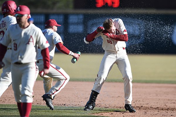 Arkansas outfielder Heston Kjerstad is doused with water by catcher Casey Opitz after Kjerstad hit the game-winning single in the Razorbacks' 3-2 win over Eastern Illinois on Sunday, Feb. 17, 2019, in Fayetteville. 