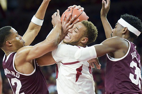 Arkansas forward Daniel Gafford is trapped by two Mississippi State defenders during a game Saturday, Feb. 16, 2019, in Fayetteville.	