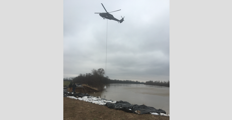 A National Guard helicopter works to reinforce a damaged levee on the banks of the White River on Saturday. Photo by Jackson County Judge Jeff Phillips. 