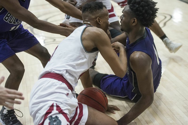 NWA Democrat-Gazette/BEN GOFF @NWABENGOFF Austin Garrett (right) of Fayetteville and Tavari Eckwood of Springdale High tussle on the floor at the end of the game Friday, Feb. 15, 2019. Garrett was assessed a flagrant foul on the play, setting off a melee which brought players and fans of both teams onto the court. Multiple players from each team face suspension from tonight's 6A-West games, including Garrett, who was ejected for the flagrant foul.