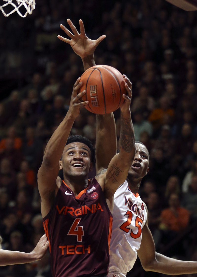 Nickeil Alexander-Walker (4) of Virginia Tech drives to the basket and is fouled from behind by Mamadi Diakite (25) of UVa in the first half of the Virginia Tech - University of Virginia NCAA basketball game in Blacksburg Va., Monday, Feb. 18 2019. (Matt Gentry/The Roanoke Times via AP)