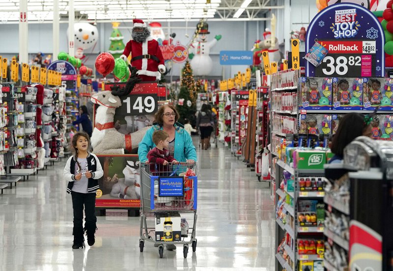 In this Friday, Nov. 9, 2018, file photo shoppers walks down an isle at a Walmart Supercenter in Houston. Walmart Inc. reports financial results Tuesday, Feb. 19, 2019. (AP Photo/David J. Phillip, File)