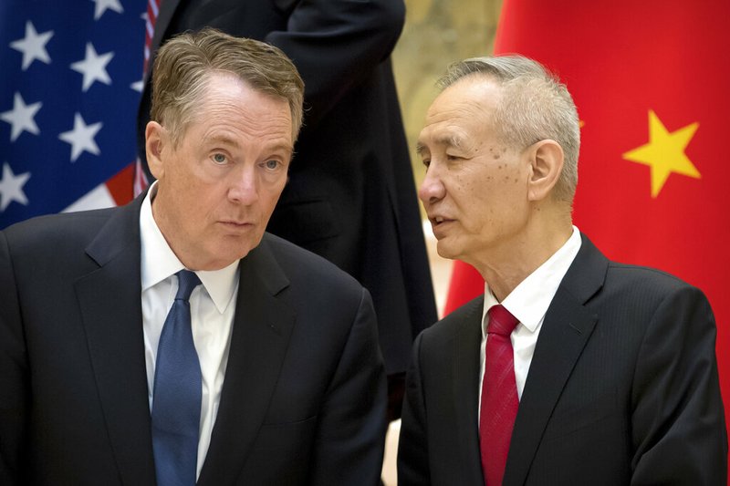 In this Feb. 15, 2019, file photo, Chinese Vice Premier Liu He, right, talks with U.S. Trade Representative Robert Lighthizer, while they line up for a group photo at the Diaoyutai State Guesthouse in Beijing. China's economy czar is going to Washington for talks Thursday and Friday aimed at ending a tariff war over Beijing's technology ambitions.(AP Photo/Mark Schiefelbein, File)