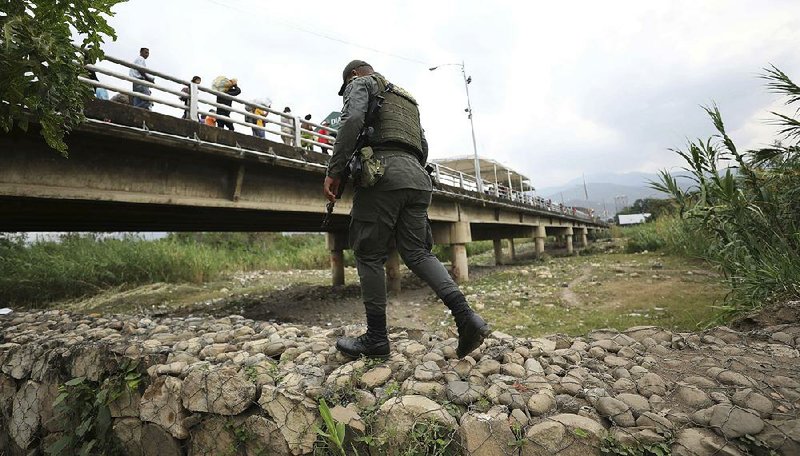 A police officer in La Parada, Colombia, patrols Tuesday near a bridge that connects Colombia and Venezuela. 