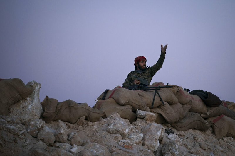 A U.S.-backed Syrian Democratic Forces (SDF) fighter reacts as an airstrike hits territory still held by Islamic State militants in the desert outside Baghouz, Syria, Tuesday, Feb. 19, 2019. The Islamic State group has been reduced from its self-proclaimed caliphate that once spread across much of Syria and Iraq at its height in 2014 to a speck of land on the countries' shared border. (AP Photo/Felipe Dana)