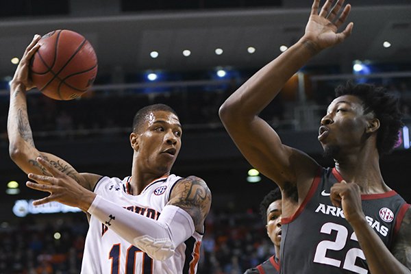 Auburn guard Samir Doughty (10) passes the ball around Arkansas forward Gabe Osabuohien (22) during the first half of an NCAA college basketball game Wednesday, Feb. 20, 2019, in Auburn, Ala. (AP Photo/Julie Bennett)

