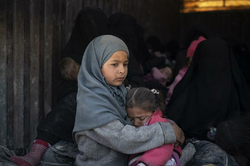 Children ride in a truck Wednesday, part of a convoy carrying hundreds of civilians out of Baghouz, the last Islamic State enclave in eastern Syria. At least 22 trucks left the enclave during the day.