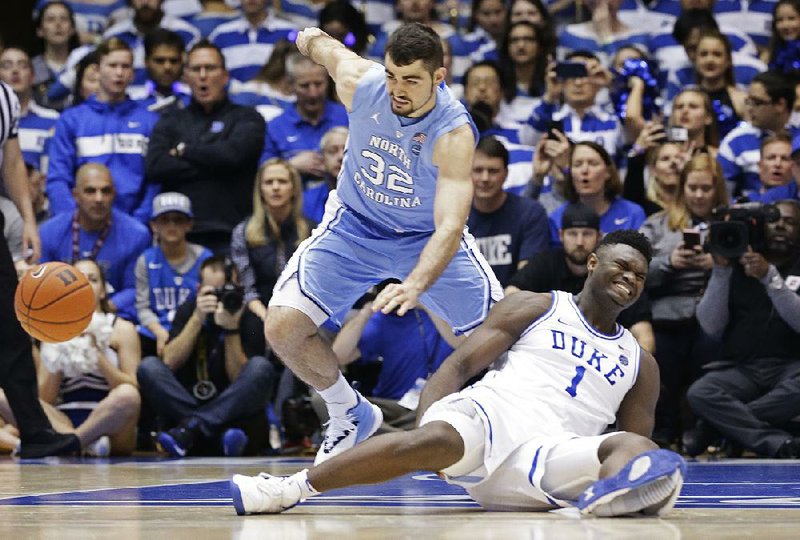 Duke freshman Zion Williamson (1) falls to the floor during the first half of the top-ranked Blue Devils’ loss to No. 8 North Carolina on Wednesday night in Durham, N.C. Williamson suffered a knee injury on the play and did not return. 