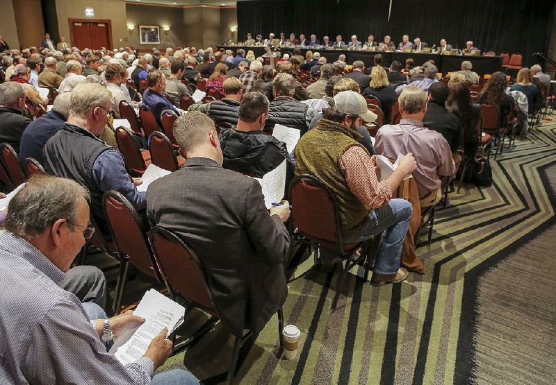 FILE - Participants look over proposed rules for the use of the herbicide dicamba at a meeting of the state Plant Board at the Embassy Suites Hotel in west Little Rock.