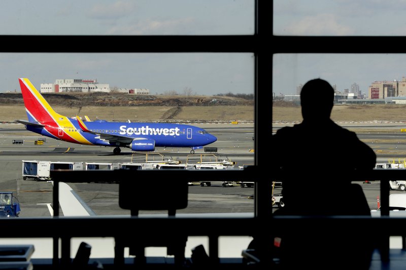 In this Jan. 25, 2019, file photo a Southwest Airlines jet moves on the runway as a person eats at a terminal restaurant at LaGuardia Airport in New York. Southwest Airlines is lashing out at the union representing its mechanics and suggesting that workers are purposely grounding planes to gain leverage in negotiations over a new contract. Southwest had canceled more than 400 flights, 10 percent of its schedule, by midmorning Wednesday, Feb. 20. (AP Photo/Julio Cortez, File)