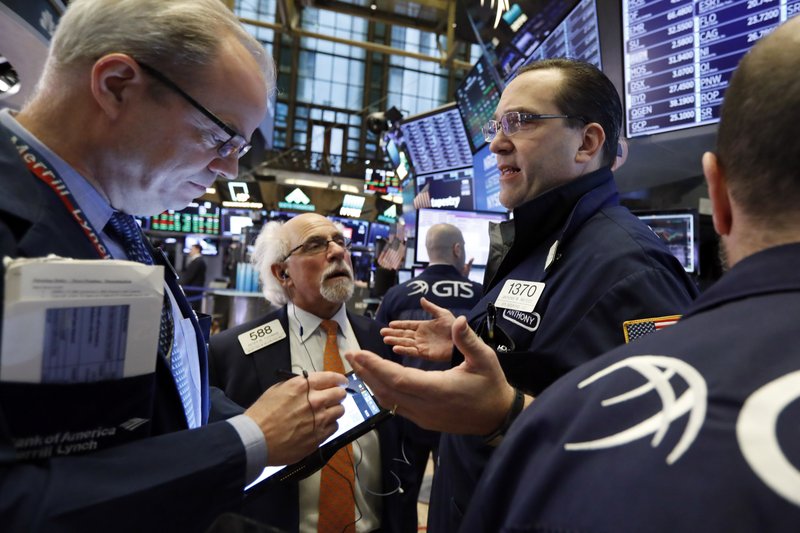 In this Feb. 15, 2019, file photo specialist Anthony Matesic, right, works with traders on the floor of the New York Stock Exchange.  (AP Photo/Richard Drew, File)