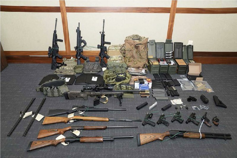 This photo provided by the U.S. District Court in Maryland shows the weapons and ammunition that authorities reported seizing in Coast Guard Lt. Christopher Paul Hasson’s basement apartment in Silver Spring, Md. 