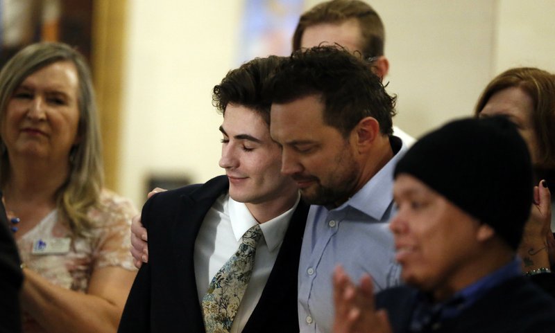Nathan Dalley, center, receives a hug after speaking during a news conference at the Utah State Capitol Thursday, Feb. 21, 2019, in Salt Lake City. Two Republican lawmakers proposed a ban on gay conversion therapy for minors in conservative Utah on Thursday, a plan that's been hailed as a milestone by advocates and won't be opposed by the influential Mormon church. Those who have been through conversion therapy, like 19-year-old Dalley, say it leaves them depressed and can lead to suicide attempts. (AP Photo/Rick Bowmer)