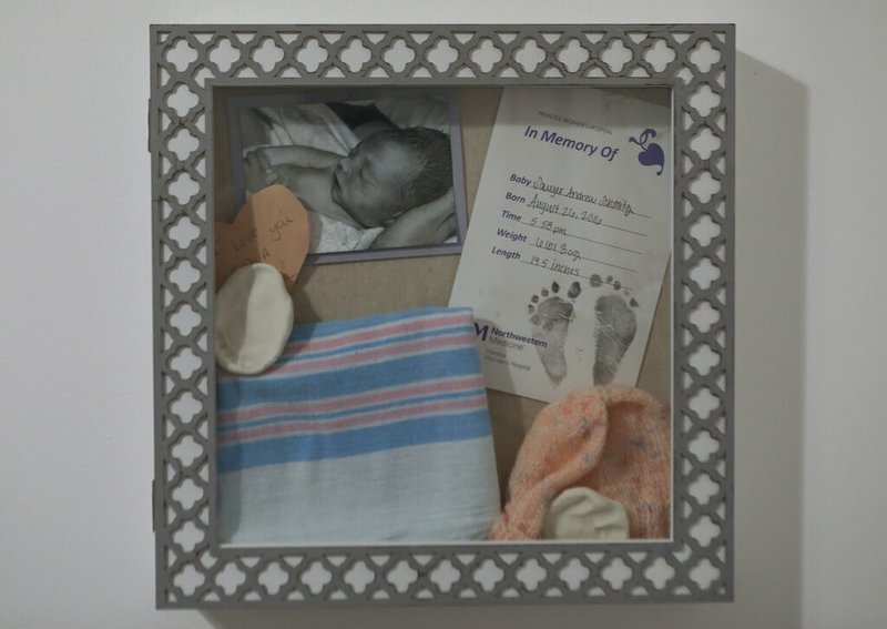 In this Monday, Feb. 18, 2019 photo, a memory box dedicated to stillborn Sawyer Schmitz is seen on the wall of the home of Lindsey Schmitz in Chicago. She says she's wracked by the things that in her grief she didn't think to do _ "cut a lock of his hair, read a book to him, we never dressed him. At that moment, you just don't know that's what you're going to want." (AP Photo/Teresa Crawford)