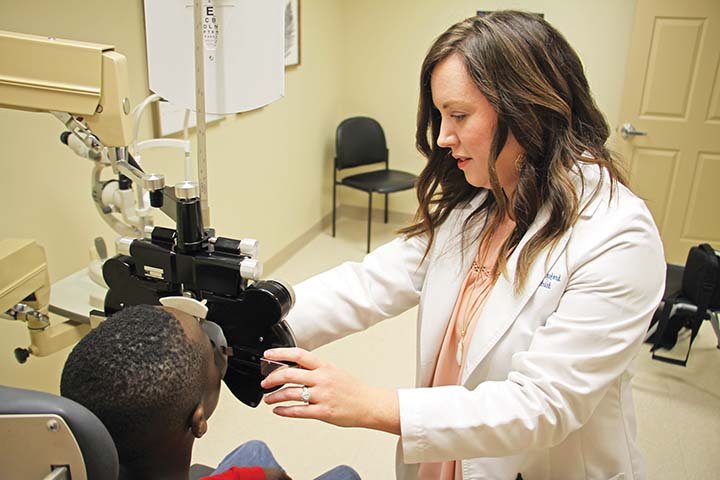 Dr. Sarah Lunsford, with the EyeCare Center of Saline County, gives Ira Lasiter, 8, a vision checkup during a visit Feb. 6. The Hornet Health Center, on the campus of Bryant Elementary School, now offers vision care once a week.