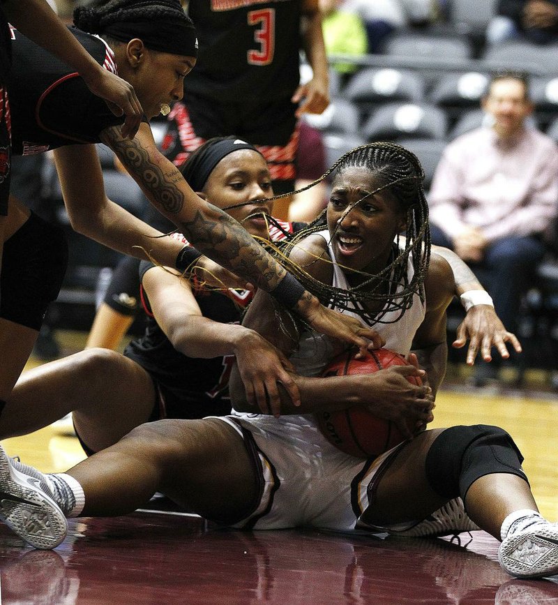 UALR’s Raeyana DeGray (right) fights for a loose ball with Arkansas State’s Peyton Martin during the Trojans’ 68-55 victory over the Red Wolves on Feb. 2. The teams meet again today in Jonesboro.