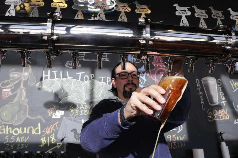 NWA Media/ J.T. Wampler -Shea Singleton pours a pint of Imperial Red Wednesday Jan. 7, 2014 at Core Pub Rogers. The pub served beer from Core Brewing and Distilling Company in Springdale. The company recently announced the closing of multiple pubs in Northwest Arkansas, including its Rogers location.